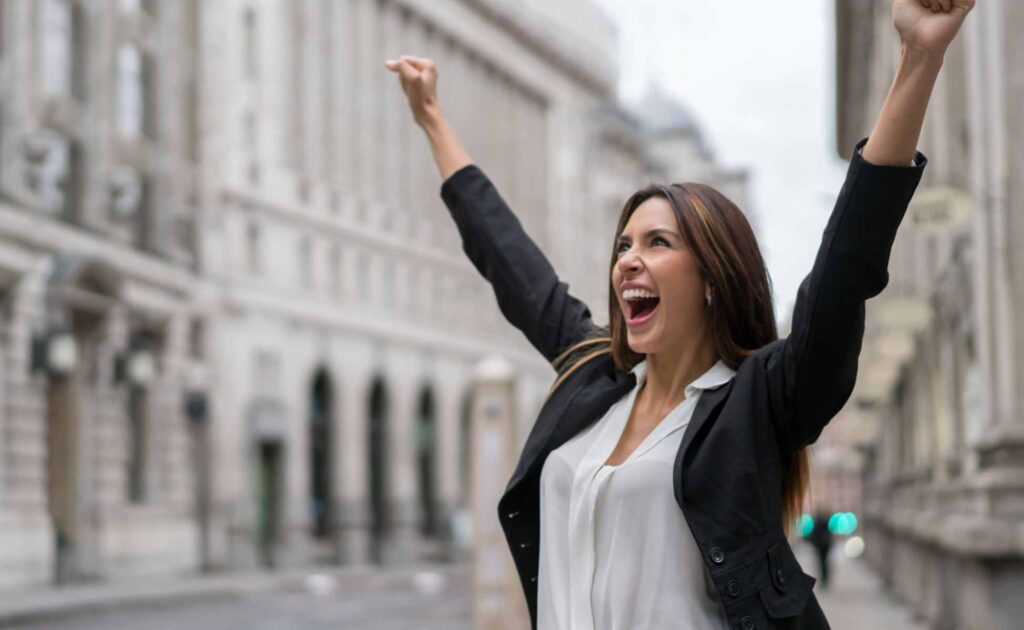 Mujer celebrando su éxito tras reclamar los intereses abusivos de una tarjeta revolving y recuperar su dinero